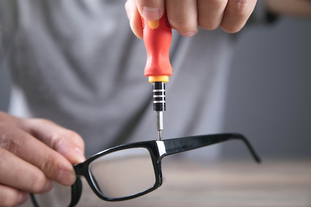 Technicien Optique Réparant Des Lunettes Avec Un Tournevis