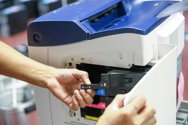 Technicien photocopieur à couvercle ouvert pour remplacer les cartouches d'encre