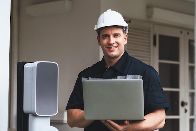 Technicien qualifié travaillant avec un ordinateur portable pour les synchronisateurs de station d'électricité à domicile