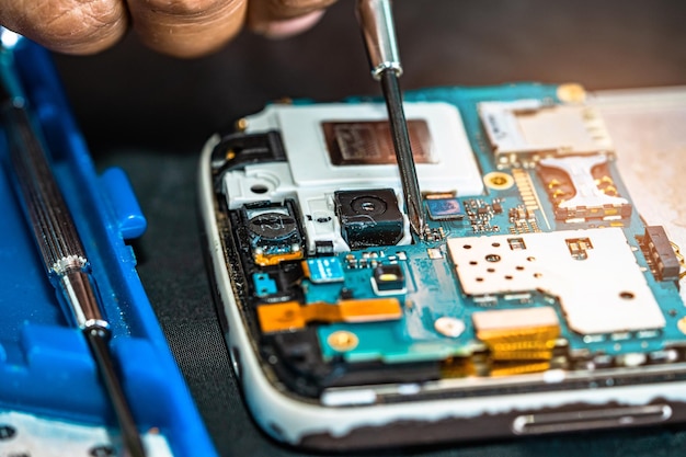 Technicien réparant à l'intérieur du téléphone mobile en fer à souder Circuit intégré le concept de la technologie du matériel de données