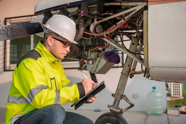 Technicien réparant le moteur de l'avionFemme d'ingénierie aérospatiale vérifiant les moteurs d'avionLa maintenance mécanique asiatique inspecte le moteur d'avion