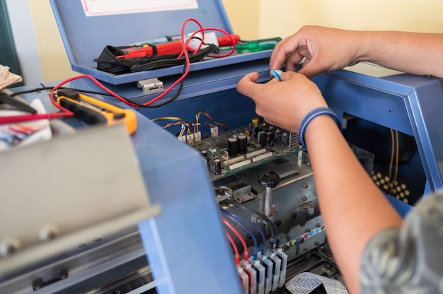 Technicien réparant le système de carte mère des distributeurs de couleurs de l'imprimante à jet d'encre