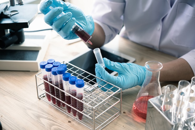 technicien de santé avec des tubes de sang dans le laboratoire clinique pour analytique, Médical, pharmaceutique