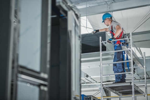 Technicien de ventilation de l'air vérifiant l'arbre installé