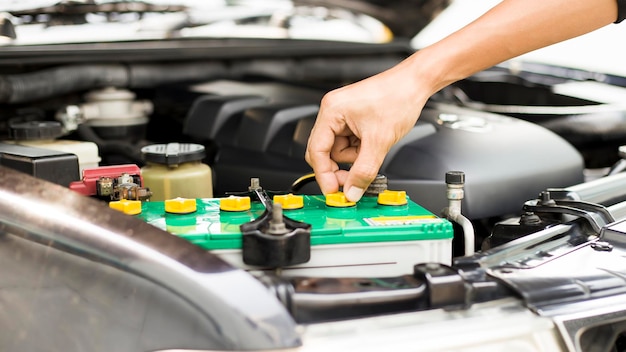 technicien vérifiant la batterie de la voiture.