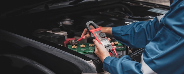 Technicien vérifiant le système électrique de la voiture