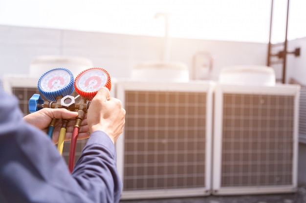 Un technicien vérifie le climatiseur et mesure le remplissage des climatiseurs.