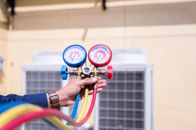 Un technicien vérifie le climatiseur et mesure le remplissage des climatiseurs.