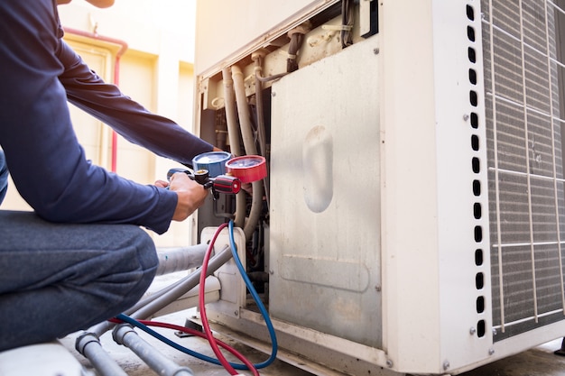 Photo un technicien vérifie le climatiseur et mesure le remplissage des climatiseurs.