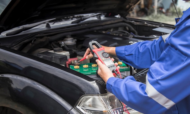 Un technicien vérifie la disponibilité de la batterie de la voiture.