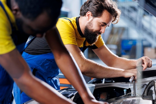 Photo techniciens dans un garage qui réparent les freins de voiture