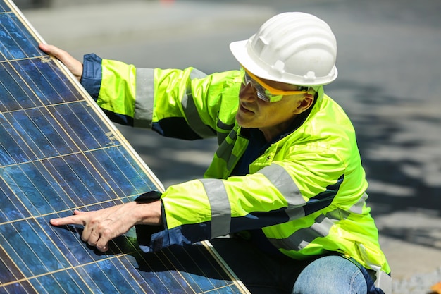 Les techniciens entretiennent le panneau solaire et vérifient la cellule travaillant avec une tablette pour le renouvellement de l'alternative à la maison