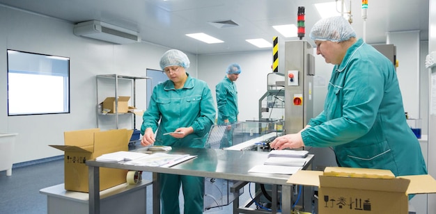 Les techniciens pharmaceutiques travaillent dans des conditions de travail stériles à l'usine pharmaceutique Les scientifiques portent des vêtements de protection