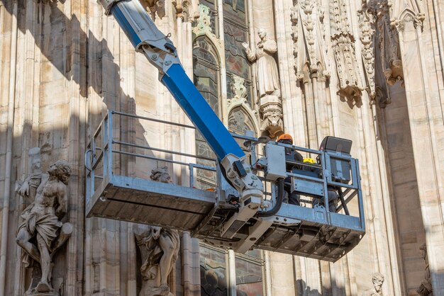 Techniciens sur plateforme élévatrice pour plan de maintenance programmé et étude des phénomènes de dégradation de la cathédrale de Milan