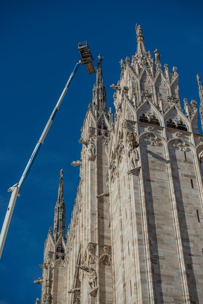 Techniciens sur plateforme élévatrice pour plan de maintenance programmé et étude des phénomènes de dégradation de la cathédrale de Milan