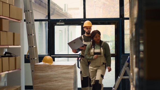 Photo les techniciens de production effectuent des contrôles des stocks en entrepôt, en maintenant des normes de qualité élevées. des experts efficaces en espace de travail de stockage se préparent à expédier les colis, en vérifiant les informations de livraison