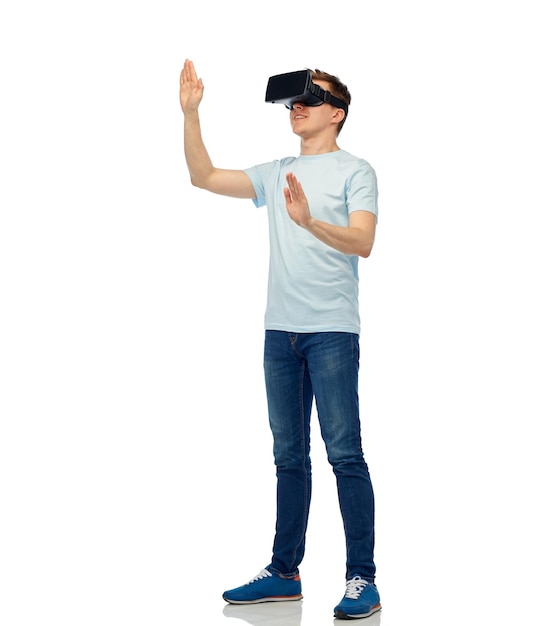 Technologie 3d, réalité virtuelle, divertissement, cyberespace et concept de personnes - jeune homme heureux avec un casque de réalité virtuelle ou des lunettes 3d jouant à un jeu et touchant quelque chose