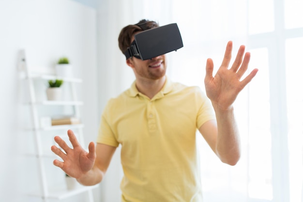 Technologie 3d, réalité virtuelle, jeu, divertissement et concept de personnes - gros plan sur un jeune homme heureux avec un casque de réalité virtuelle ou des lunettes 3d jouant à un jeu vidéo à la maison