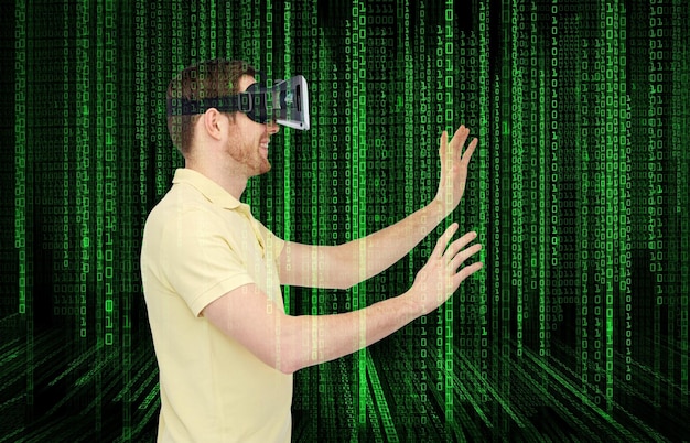 Technologie 3d, réalité virtuelle, programmation, divertissement et concept de personnes - jeune homme heureux avec un casque de réalité virtuelle ou des lunettes 3d jouant à un jeu sur des numéros de code binaires et un fond noir