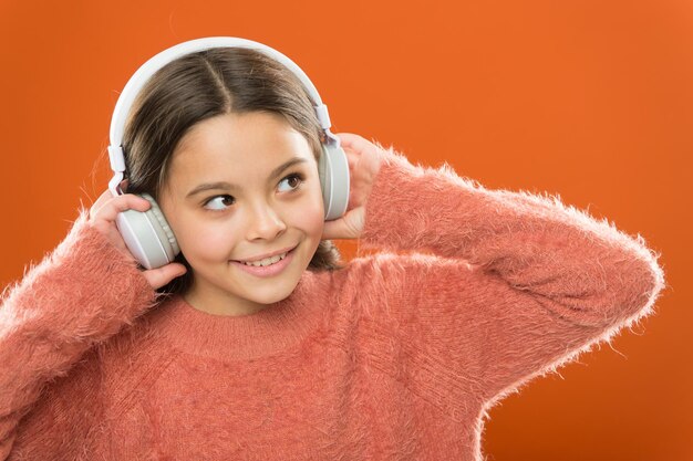 La technologie moderne est incroyable Petit enfant portant des écouteurs avec technologie Bluetooth Petite fille écoutant de la musique avec des écouteurs sans fil Technologie de son stéréo Technologie et musique