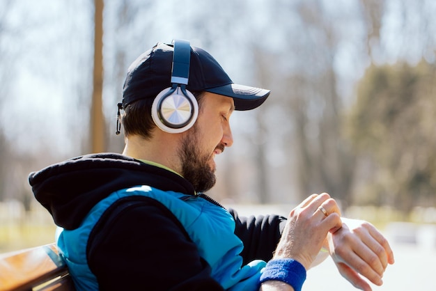 Technologie moderne et mode de vie actif un athlète souriant s'exerce avec un bracelet de fitness