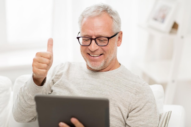 technologie, personnes et mode de vie, concept d'apprentissage à distance - homme âgé heureux avec ordinateur tablette ayant un appel vidéo à la maison