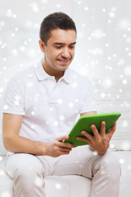 technologie, personnes et mode de vie, concept d'apprentissage à distance - homme heureux travaillant avec un ordinateur tablette à la maison sur l'effet de neige