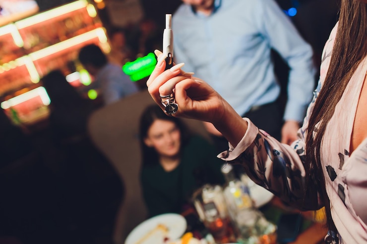 Photo technologie des produits du tabac non brûlés par la chaleur femme tenant une e-cigarette dans sa main avant de fumer