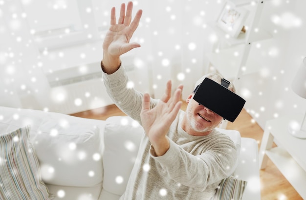 Photo technologie de réalité augmentée divertissement et concept de personnes homme âgé avec un casque virtuel ou des lunettes 3d jouant à un jeu vidéo à la maison sur la neige