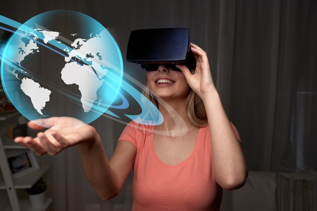 technologie, réalité virtuelle, cyberespace, concept de divertissement et de personnes - jeune femme heureuse avec un casque de réalité virtuelle ou des lunettes 3d à la maison regardant la projection du globe mondial