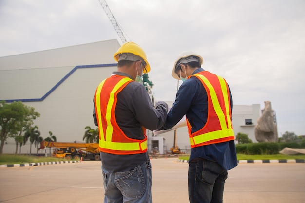 Technologie de tablette de travail de deux ingénieurs sur la construction du site