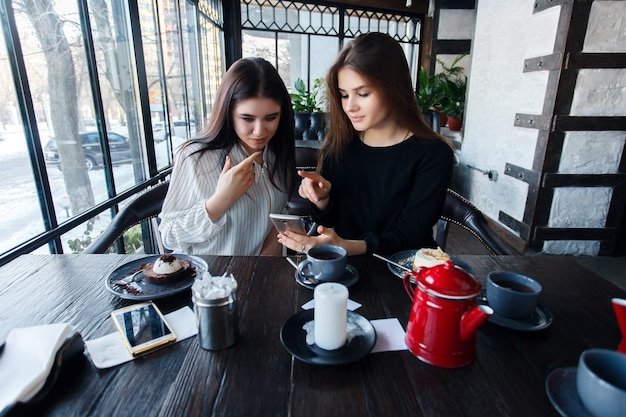 Technologies, mode de vie, nourriture, personnes, adolescents et concept de café - Deux jeunes femmes prenant un selfie avec un téléphone intelligent dans le centre-ville. Concept de bonheur sur les gens et la technologie