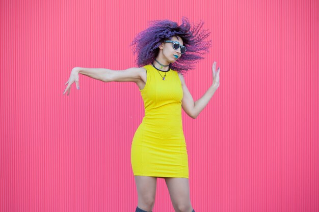 Teen Femme Aux Cheveux Afro Violet Coloré Dansant Sur Un Mur Rose