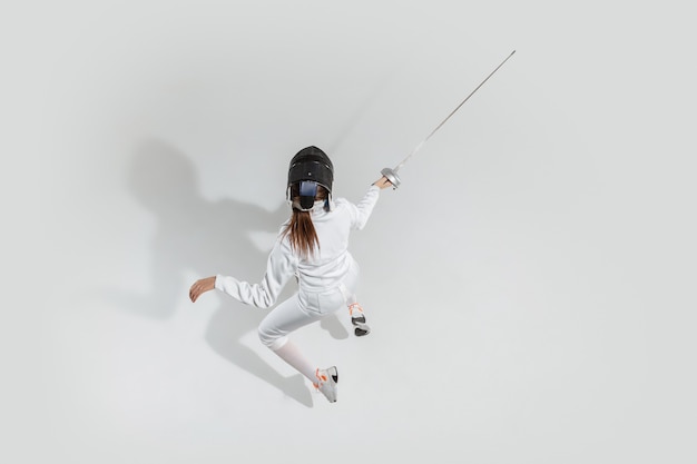 Teen girl escrime avec épée sur fond blanc, vue de dessus. Sport, action