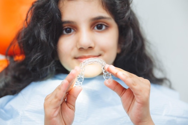 Teen girl holding accolades dentiste met des accolades sur les soins dentaires des filles et le concept orthodontique