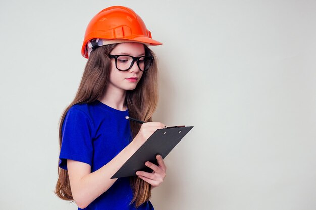 Teen girl holding peinture mur rouleau de peinture et pour la liste de contrôle son achat dans la quincaillerie.liste d'achats dans les mains d'une femme d'affaires architecte designer adolescente