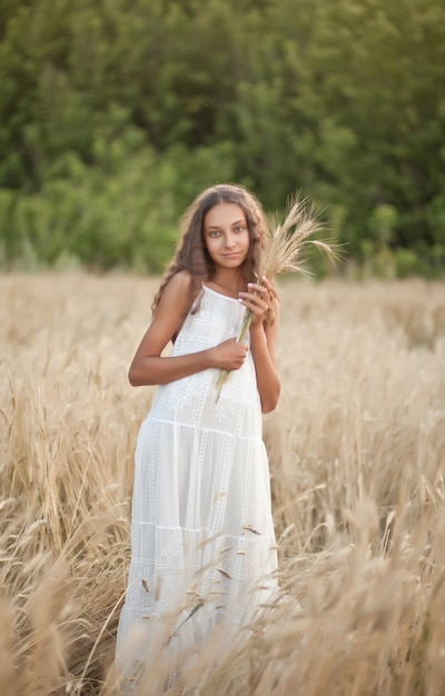 Teen girl in champ de blé dans une journée d'été.