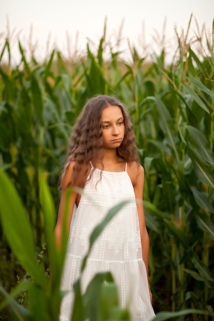 Teen girl in cors field en une journée d'été.