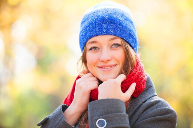 Teen girl in rouge écharpe à l'automne en plein air