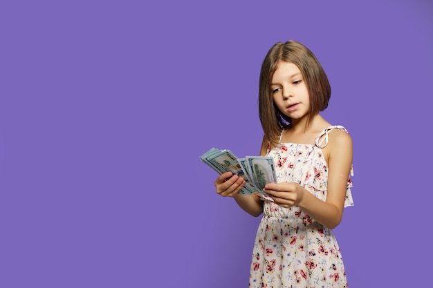 Teen girl in summer dress isolé avec des billets d'argent dollar américain sur velours
