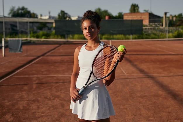 Teen girl avec raquette de tennis sur cour