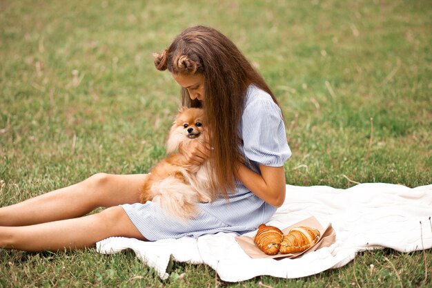 Teen girl with pet animal petit chien sur un pique-nique en plein air.