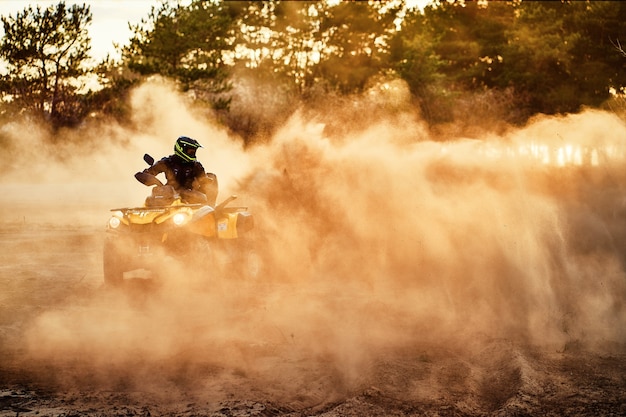 Teen riding ATV dans les dunes de sable faisant un tour dans le sable