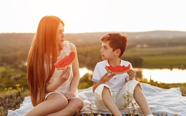 Teen soeur et petit frère mangeant de la pastèque douce