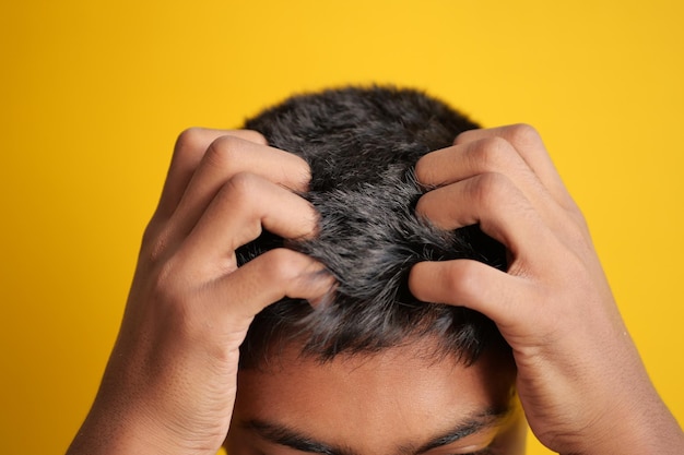 Teenage boy se gratter la tête sur fond noir