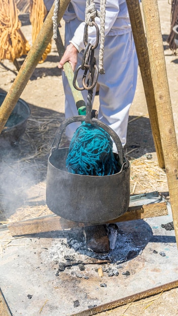 teinture artisanale de tissus et de laine dans un chaudron avec des teintures colorées dans une foire médiévale en Espagne