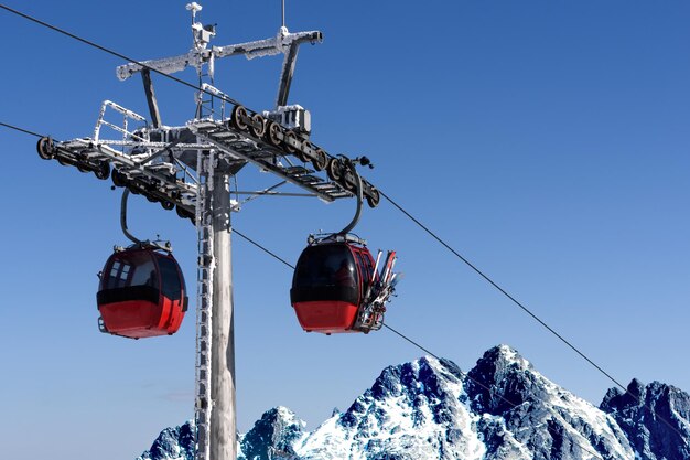 Télécabine télécabine dans la station de ski sur de hautes montagnes sur le fond de ciel bleu en journée ensoleillée