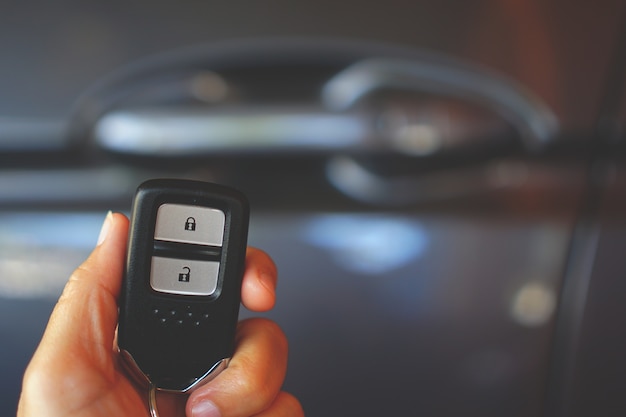 Télécommande de porte de voiture en tenant la main avec flou fond de voiture