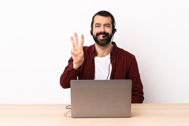 Telemarketer homme caucasien travaillant avec un casque et avec un ordinateur portable