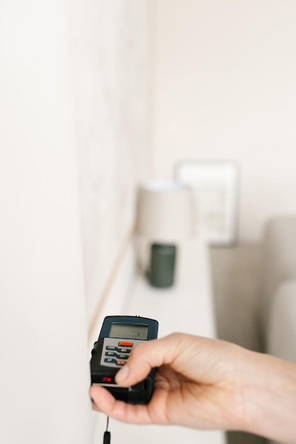 Un télémètre laser dans les mains d'une femme près d'un mur Un ingénieur tenant un télémètres laser de près avec un espace de copie